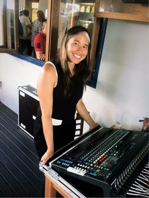 Picture of Rock Factory owner Michelle behind an allen and heath qu desk which she has since replaced with SQ5 and SQ6 digital sound desk for hire. Hire a audio technician, audio visual technician, sound technician or mix engineer