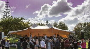 Stretch Tent Covered Stage - Large Outdoor Covered Stage perfect for community events. An example of stage hire auckland and marquee hire auckland. The stretch tent marquee make a great cover for a stage on grass and is popular with fia fia and kapa haka cultural events as well as for band stages.