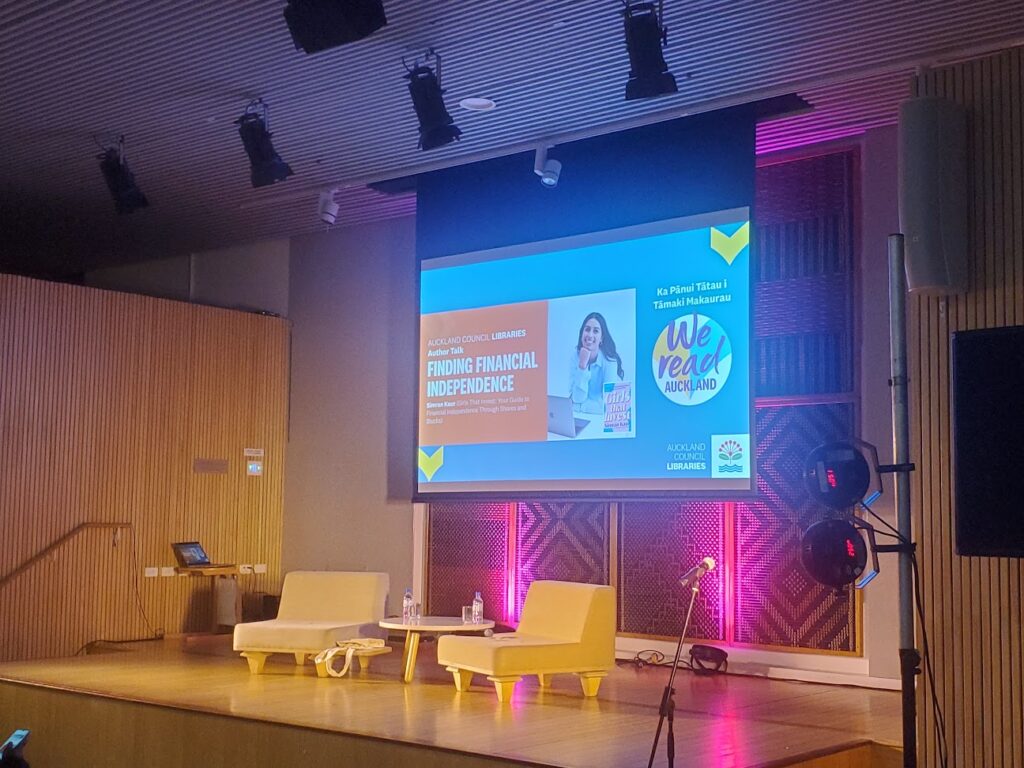 A stage set for a speaking event, with seating, atmospheric lighting, sound reinforcement, and a projector screen. Audio services for Conferences and Presentations.