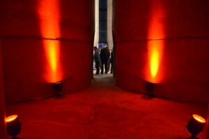 Uplighting example - Concrete walls are lit by orange lights placed on the floor pointing upwards, creating a dramatic effect.